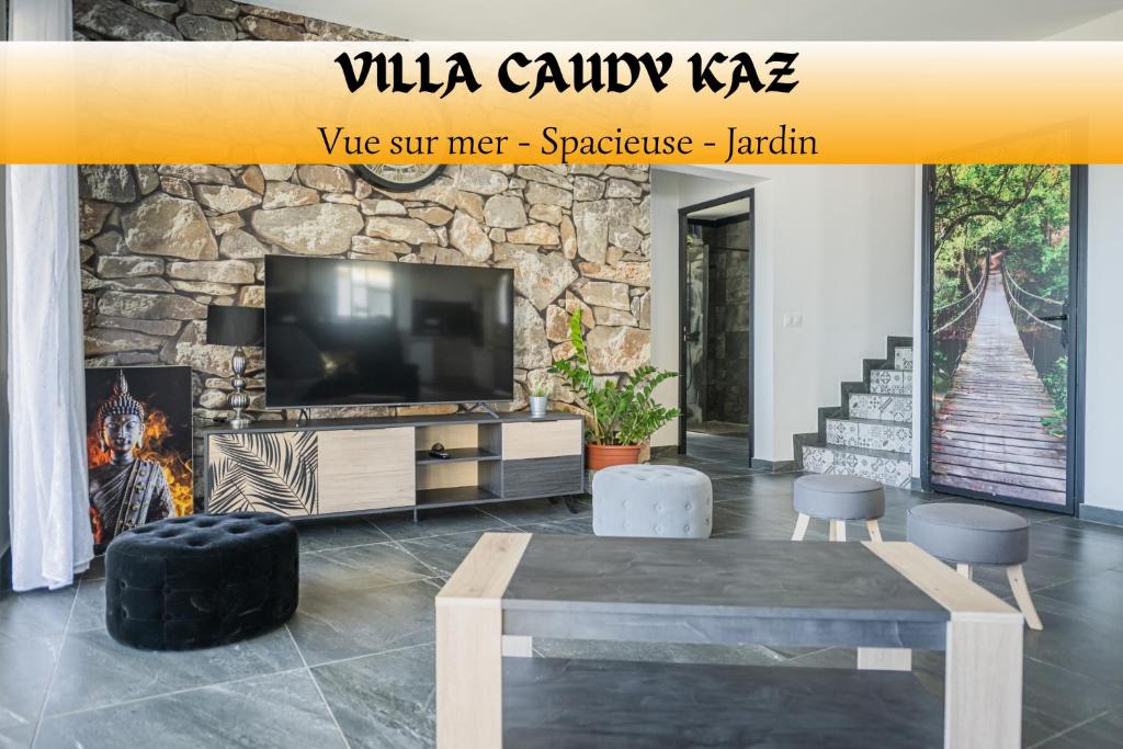 ein Wohnzimmer mit einem TV und einer Steinmauer in der Unterkunft Villa Caudy Kaz - calme et confort - Wiskeys in Sainte-Marie