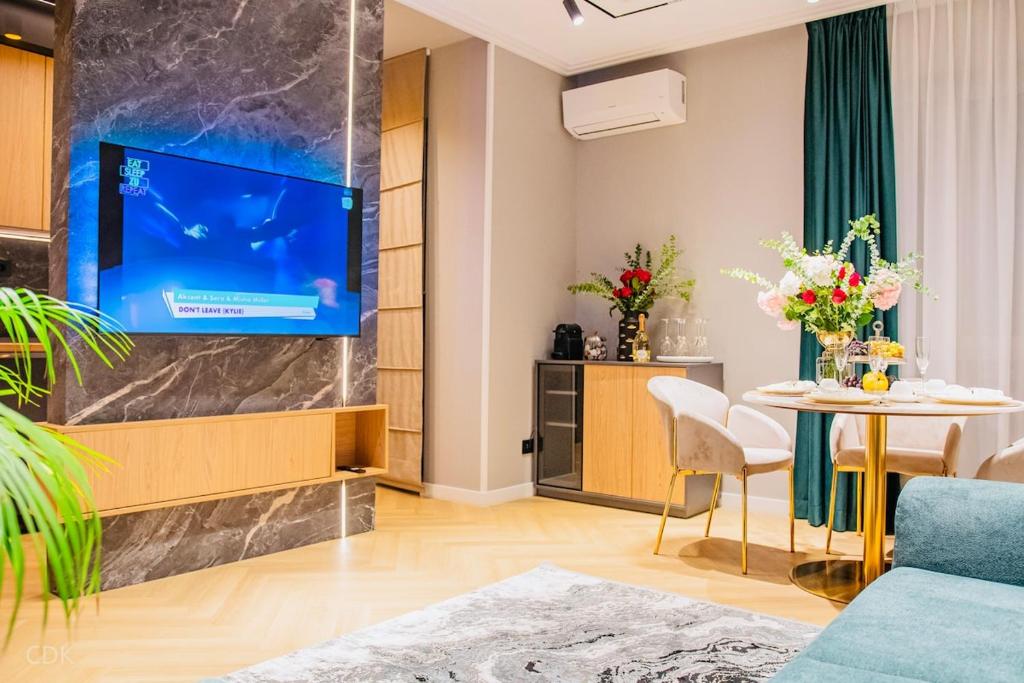 un salon avec une télévision et une table dans l'établissement Luxurious apartment by Hotel Casa David 2025, à Craiova