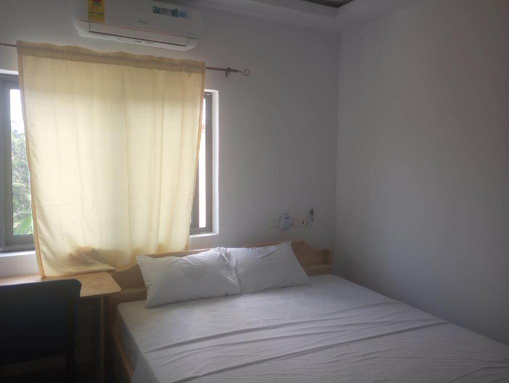 a small bed in a room with a window at Eastern Comfort Hotel in Koforidua