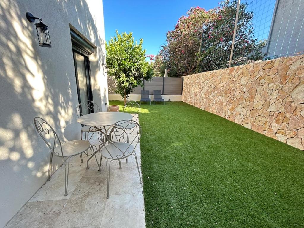 a patio with a table and chairs on a lawn at St Paul de Vence in Cagnes-sur-Mer