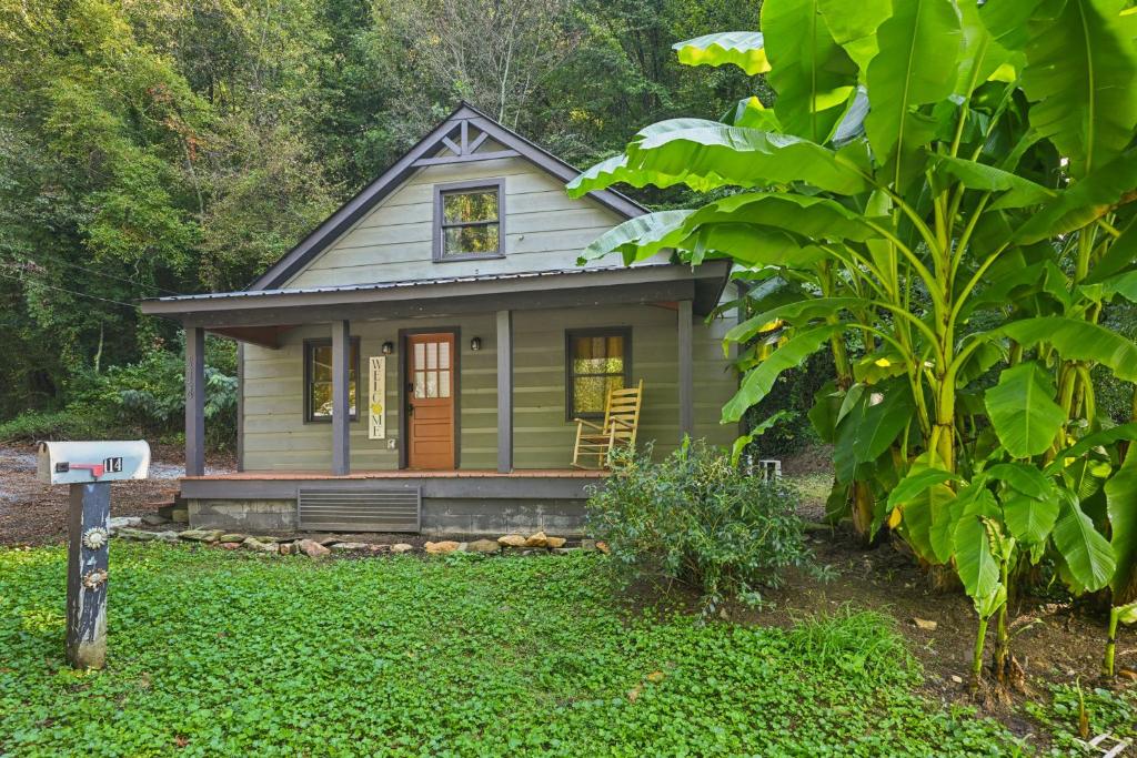 a small house in the middle of a yard at Charming Cabin with Hot Tub, Fireplace, Fire Pit, 2 minutes to downtown in Ellijay