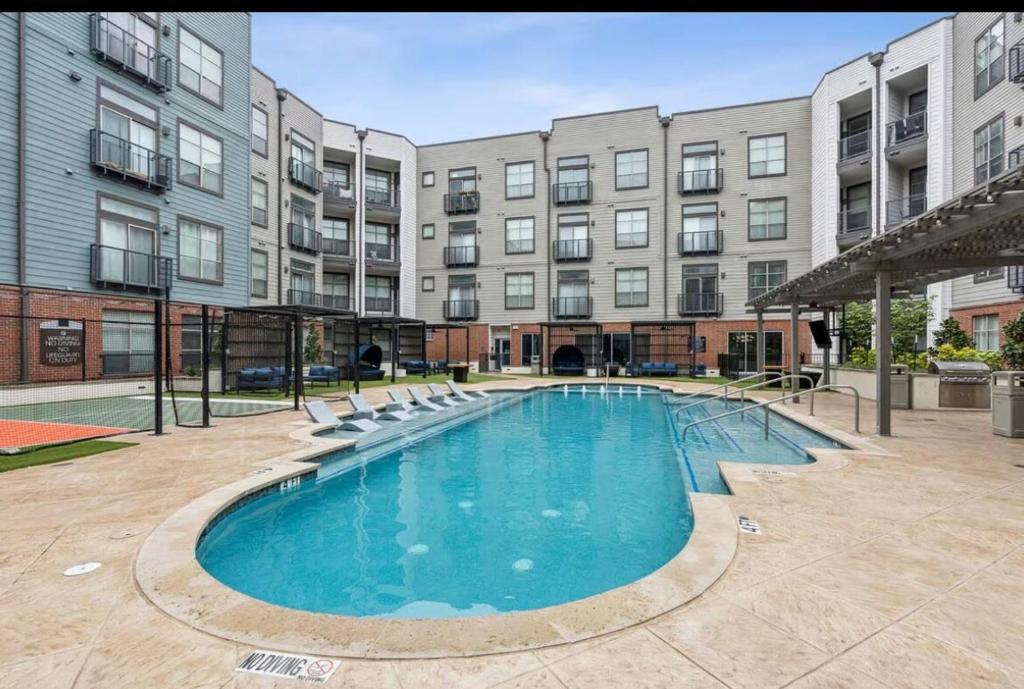 een groot zwembad voor een gebouw bij Cozy, Charming, and Chic Stay in Dallas