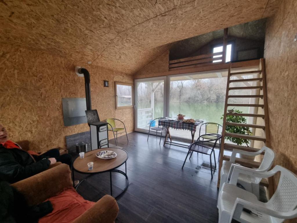 een woonkamer met een ladder en een tafel en stoelen bij Splav na Dunavcu in Ivanovo