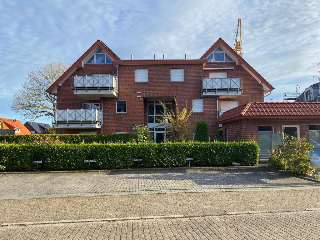 een rood bakstenen gebouw met struiken ervoor bij Meeresbrise 14 in Wangerland
