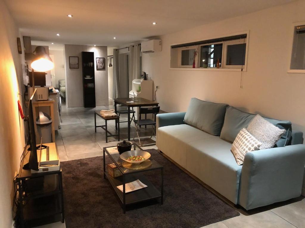 a living room with a couch and a table at Gastensuite Eindhoven B&B Flora in Eindhoven