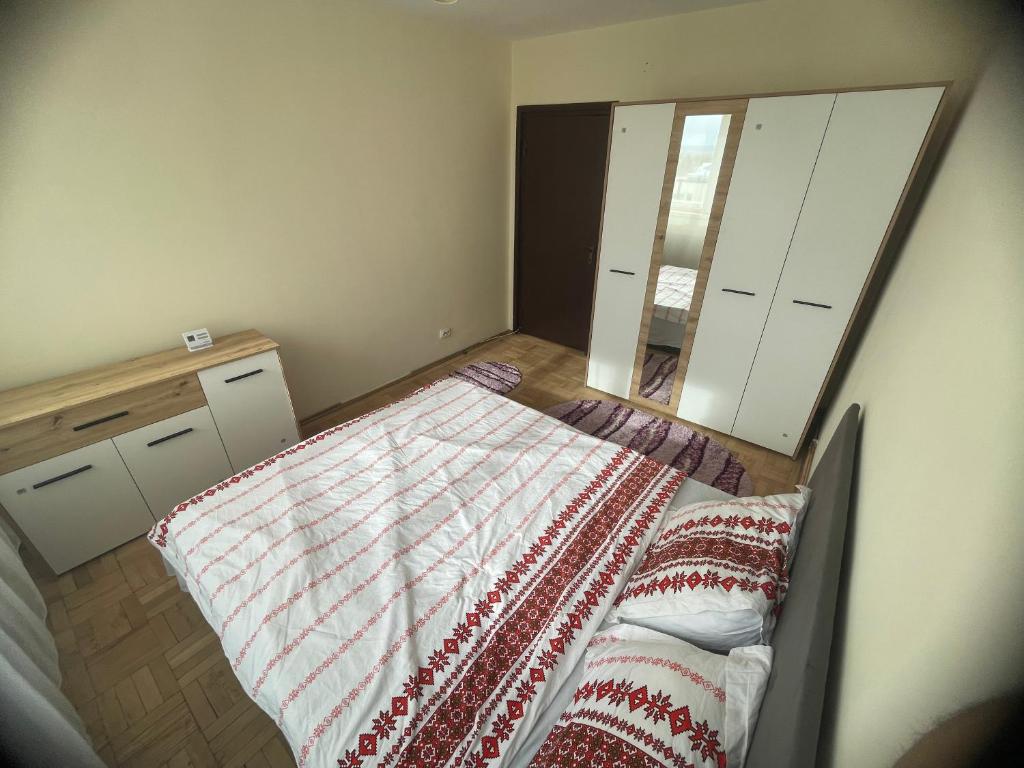 Un dormitorio pequeño con una cama y un espejo. en Apartament Eric, en Craiova