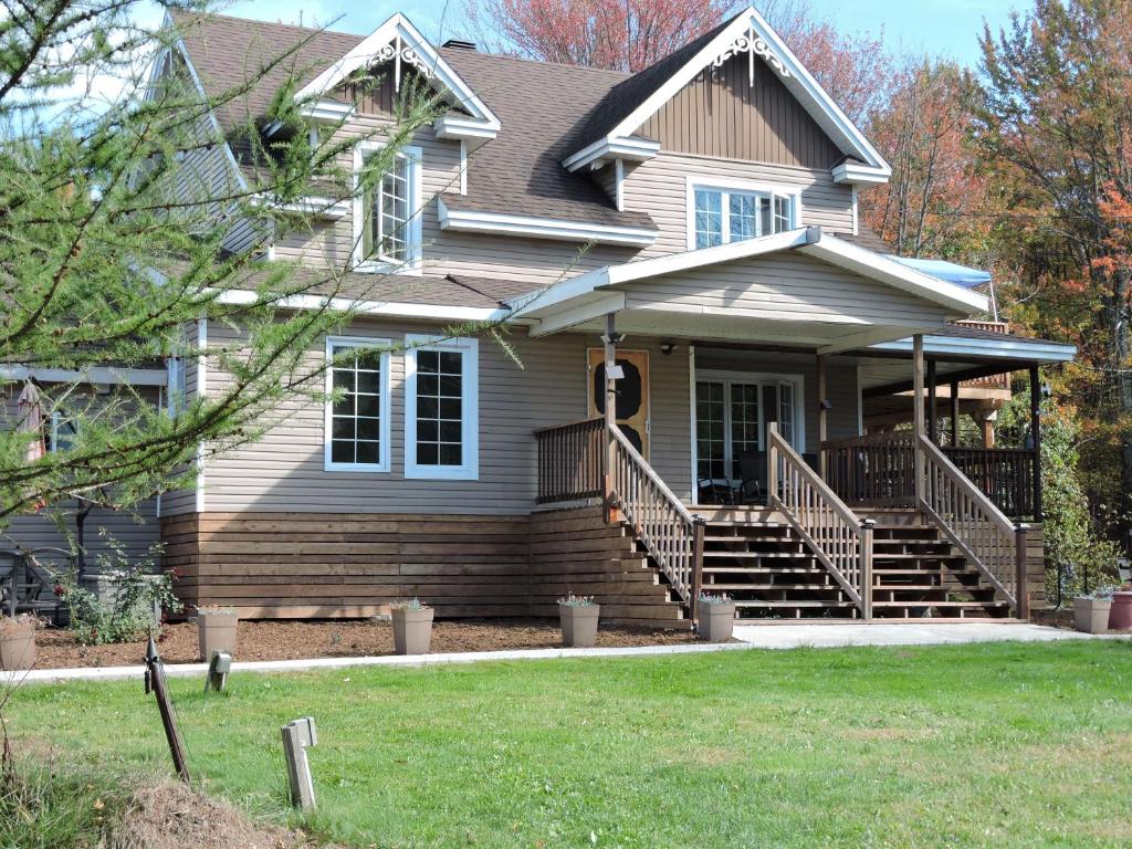 a house with a porch and stairs in a yard at Gite Passion et Tendresse B&B in Shefford