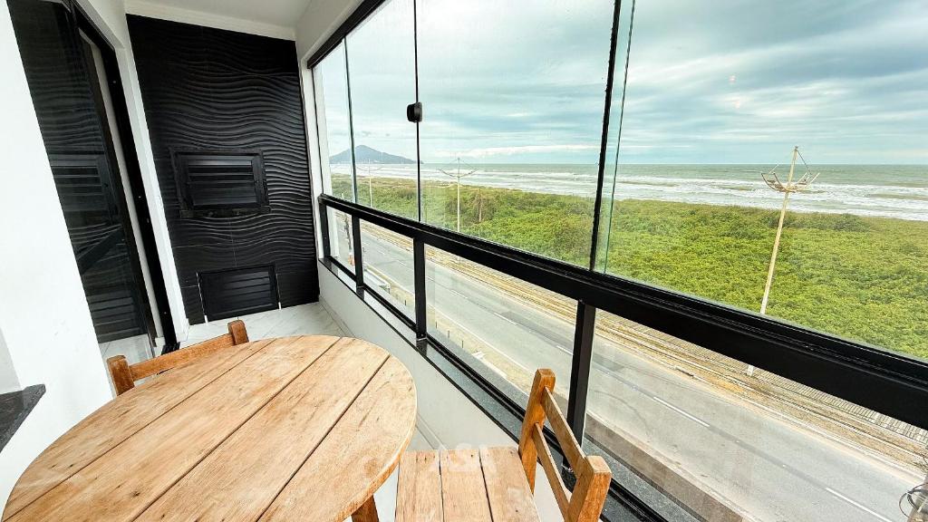 a table and chairs on a balcony with a view of the ocean at ASA | Pé na Areia | Frente-Mar Meia Praia | 2 Qtos in Navegantes