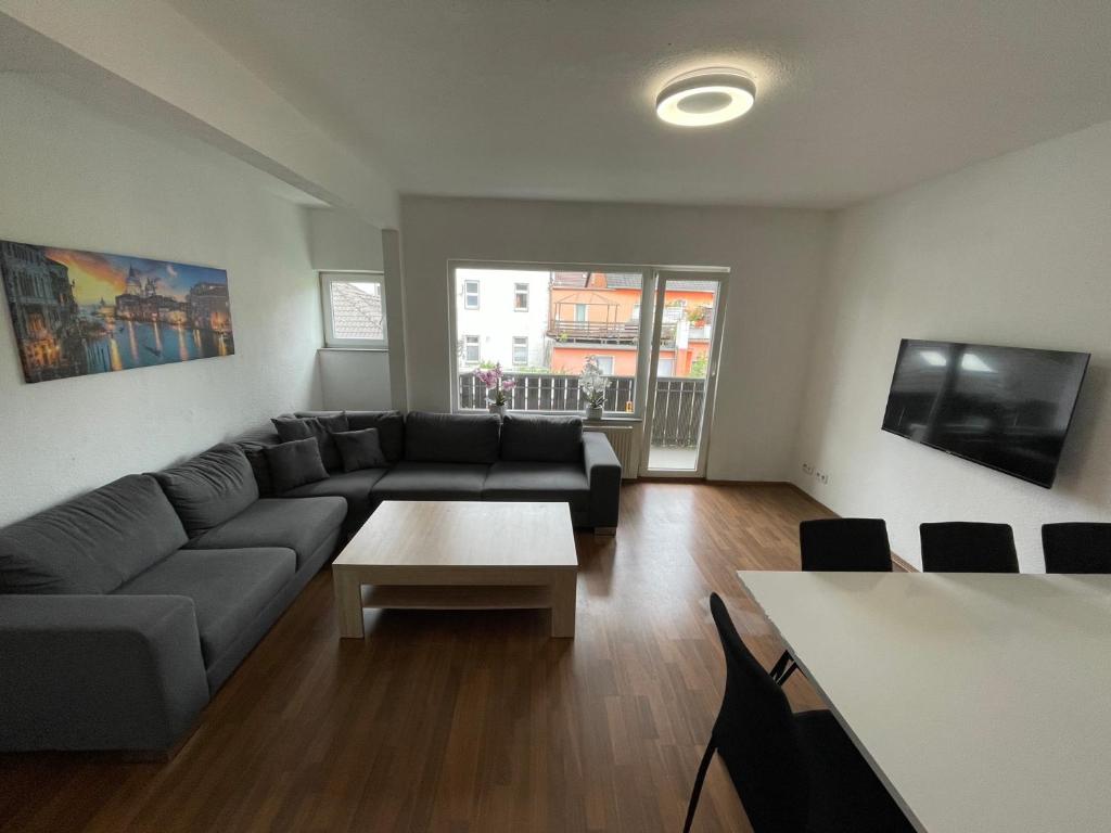 ein Wohnzimmer mit Sofa und Tisch in der Unterkunft StayBaran XL - 7 Betten I WLAN I Parkplatz I Küche in Essen