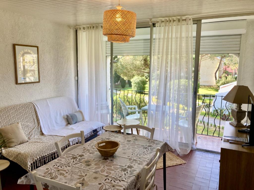 アルジェレス・シュル・メールにあるIdyllique ! Terrasse vue jardin et montagne, parking, local à vélos, à 2 pas de la plage et piscine de mai à septembre !のソファとテーブルのあるリビングルーム