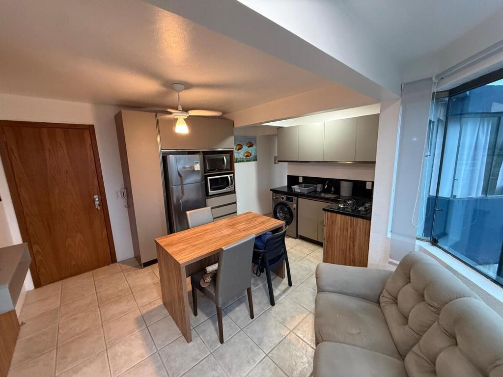 a living room with a wooden table and a couch at Entre o Mar e o Centro - A melhor Localização in Torres