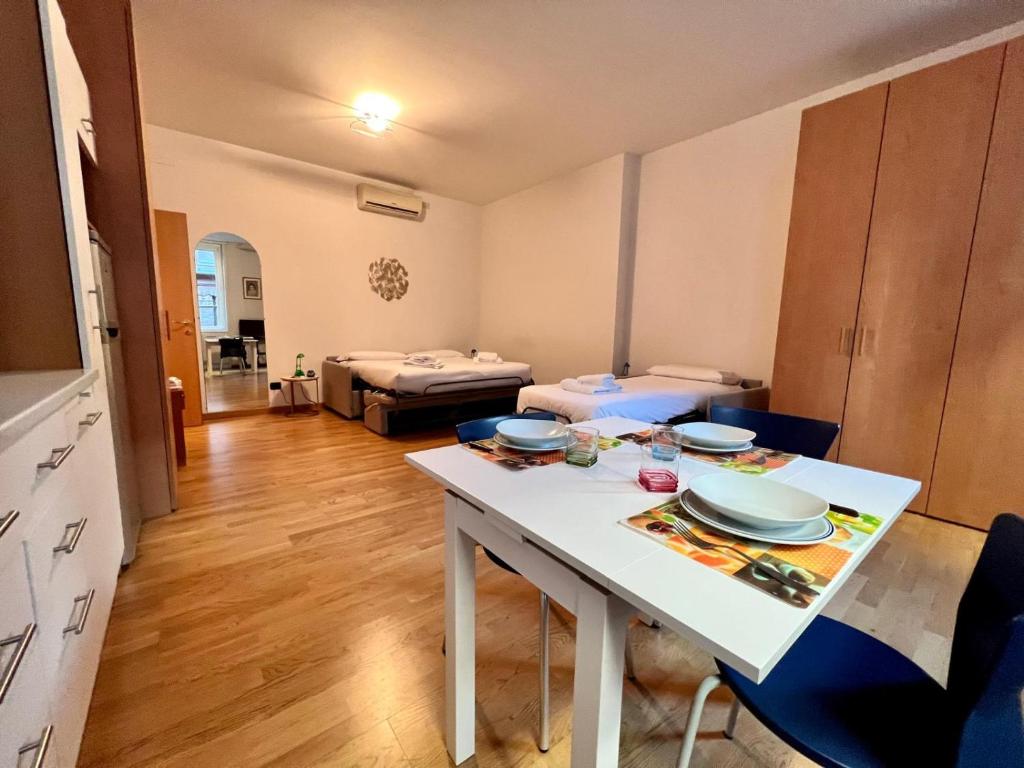 a living room with a white table and chairs at Kibilù - Cozy Studio few steps from Duomo City Centre in Milan