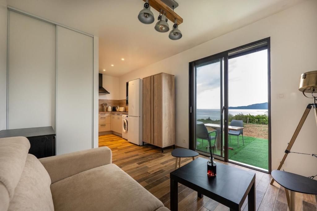 a living room with a couch and a table at Charmant Studio dans dépendance face à la mer in Serra-di-Ferro