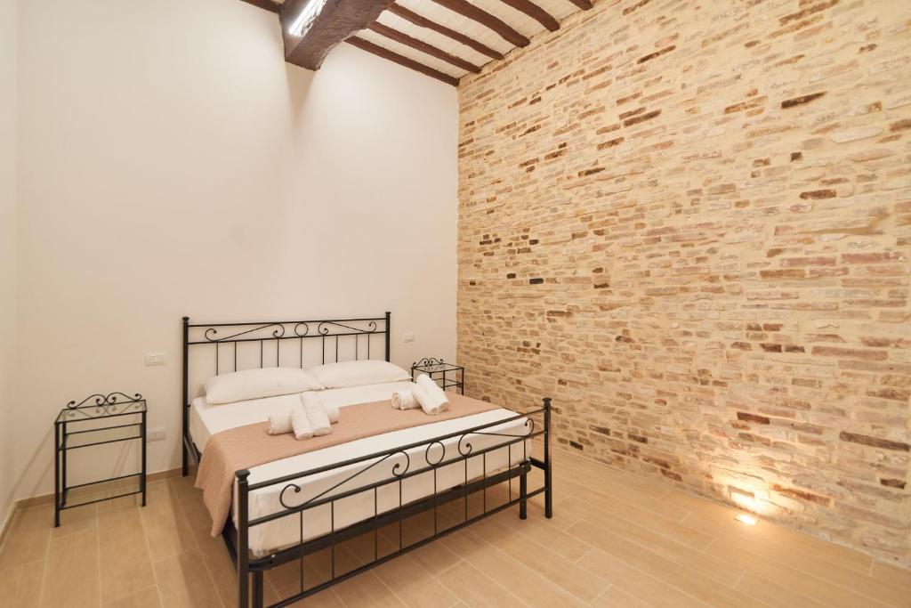 a bedroom with a bed and a brick wall at AM10 - Modern flat in historic center in Perugia