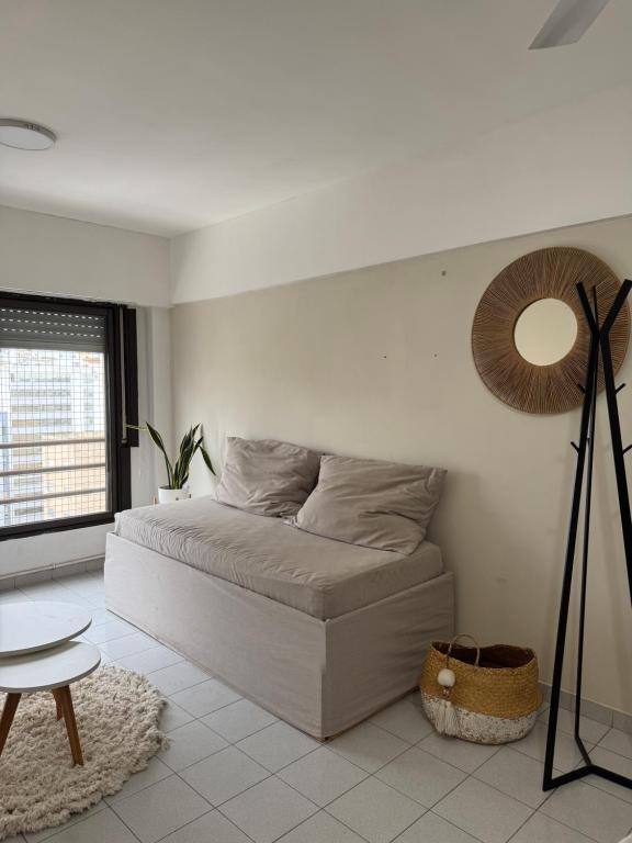 a bedroom with a bed with a mirror and a table at Departamento Bloom in Bahía Blanca