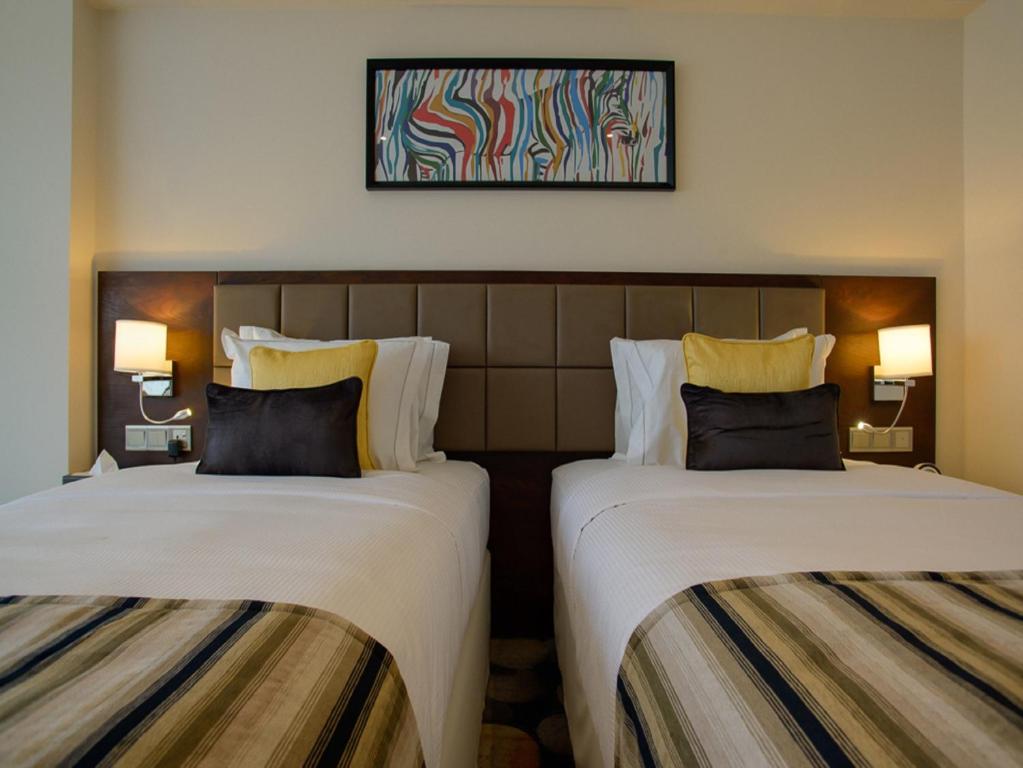 Postel nebo postele na pokoji v ubytování The Concord Hotel & Suites