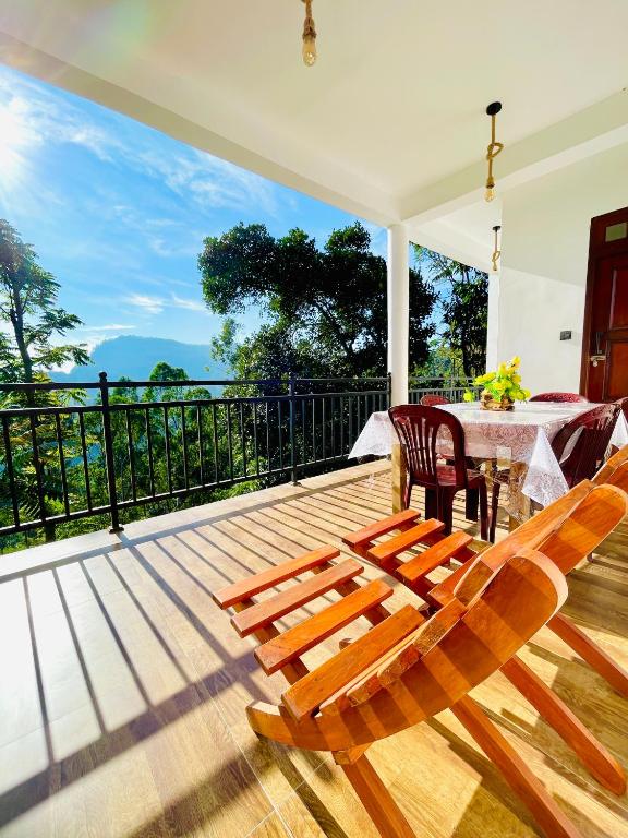 a patio with a table and chairs on a deck at Racy Nature Cottage in Ella