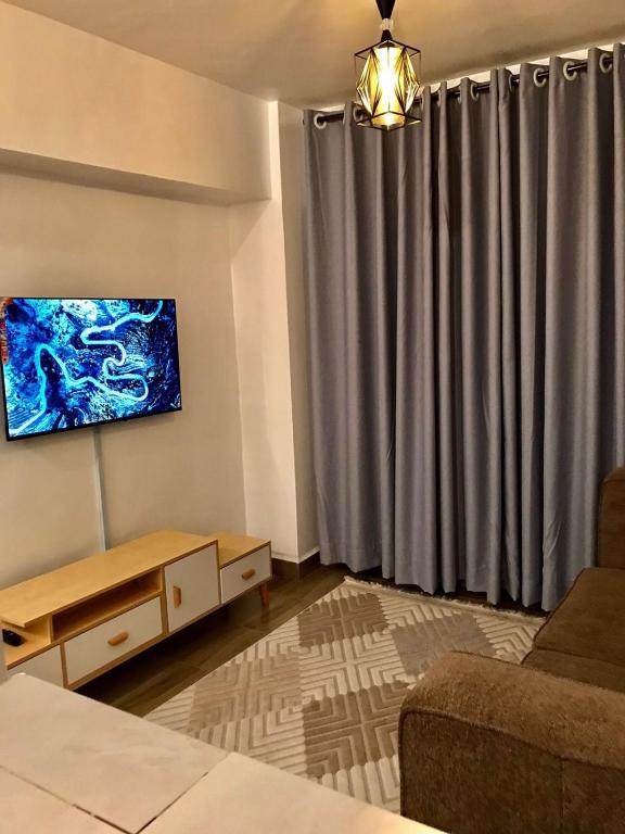 ein Wohnzimmer mit Sofa und Fernseher in der Unterkunft C&N homes Kisumu in Kisumu