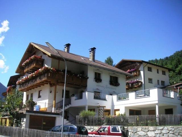 a large white building with cars parked in front of it at Gästehaus Annemarie in Kauns