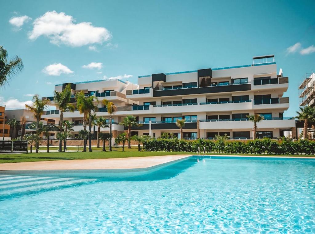 a building with a swimming pool in front of a building at Casa Madie - Sea view in Orihuela Costa