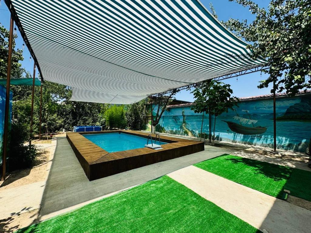 a swimming pool with a large white canopy over it at Guesthouse Gorilla 