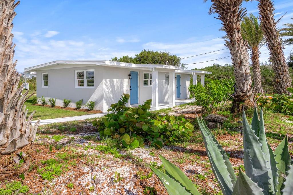 a white house with palm trees and plants at Duplex-Both Units Bungalow A&B Matanzas Launch in St. Augustine