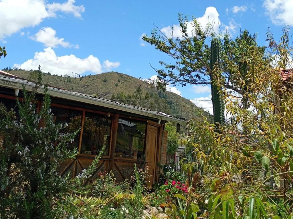 a house with a mountain in the background at El Corral in Cuenca