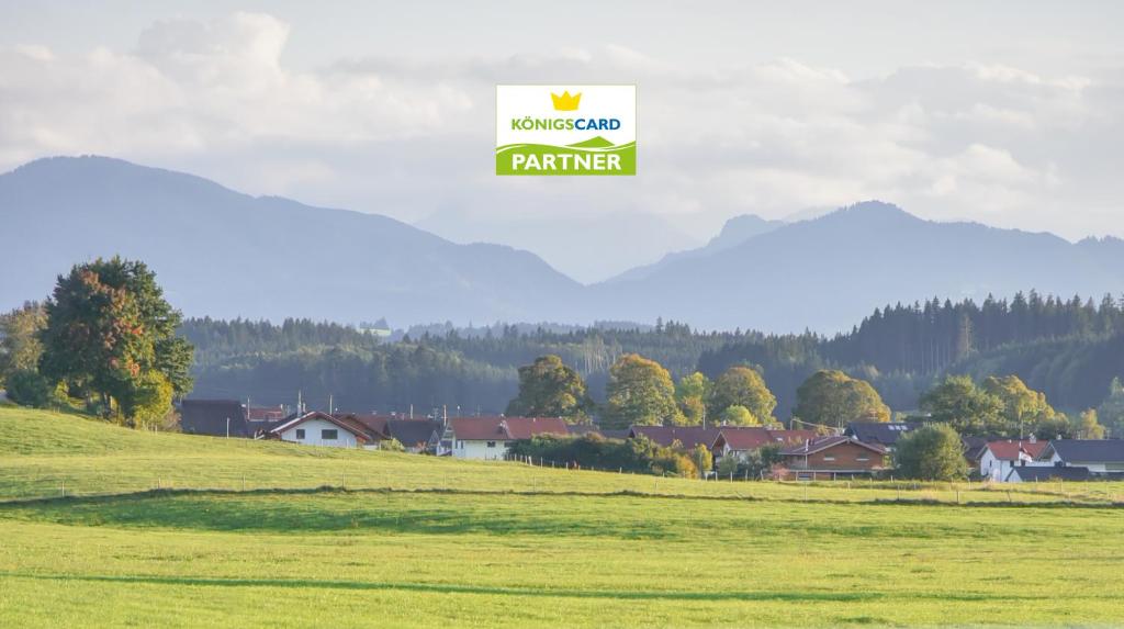 a sign in a field with houses in the background at Ferienwohnung Osterberg in Unterthingau