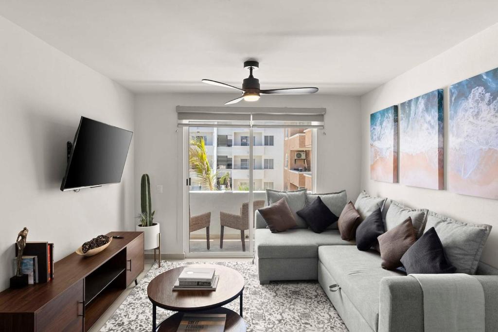 a living room with a couch and a tv at Centrally located and comfortable apartment! in Cabo San Lucas