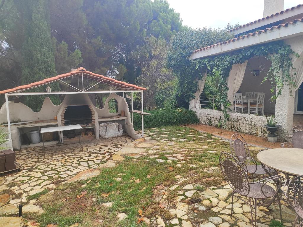 La Cubertilla en Madrid في Navas del Rey: حديقة خلفية بها شواية وطاولة وكراسي