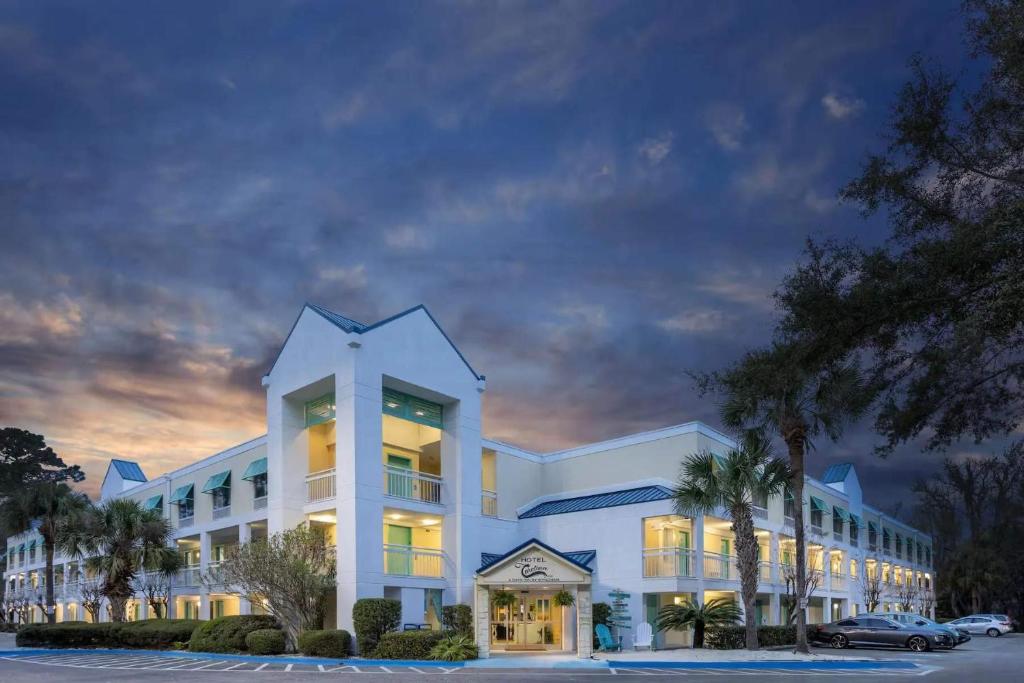 a large white building with palm trees in front of it at Hotel Carolina Double Room - 2 Queen Beds in Hilton Head Island