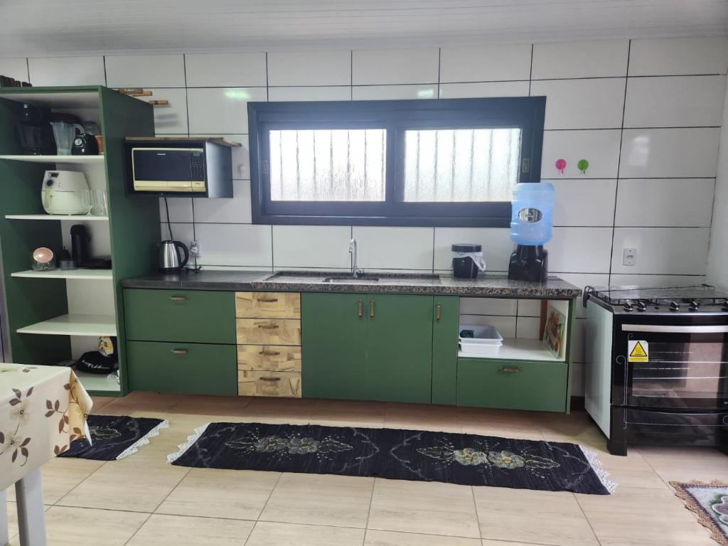 パッソ・デ・トーヘスにあるMorada do Marの緑のキャビネットと窓付きのキッチン