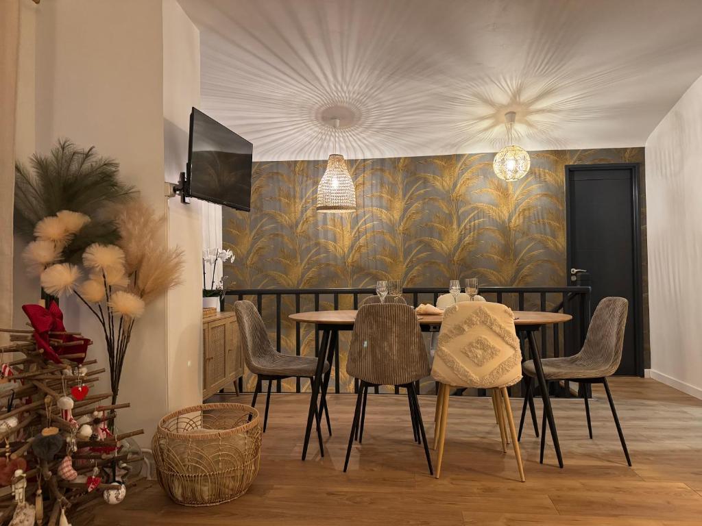 a dining room with a table and chairs and a christmas tree at Wimdream , havre de paix cosy, à deux pas de la mer et du centre ville in Wimereux