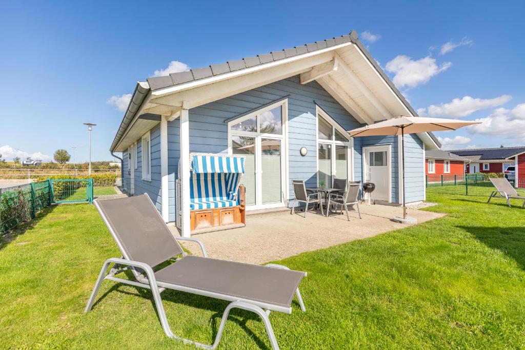 ダゲビュルにあるNordseeperleの小さな家の前の椅子と傘