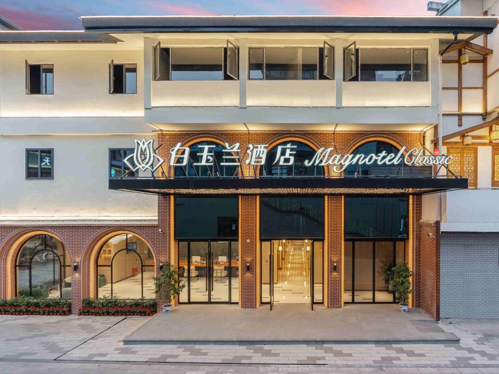 a building with a sign on the front of it at Magnotel Guilin Elephant Trunk Hill in Guilin