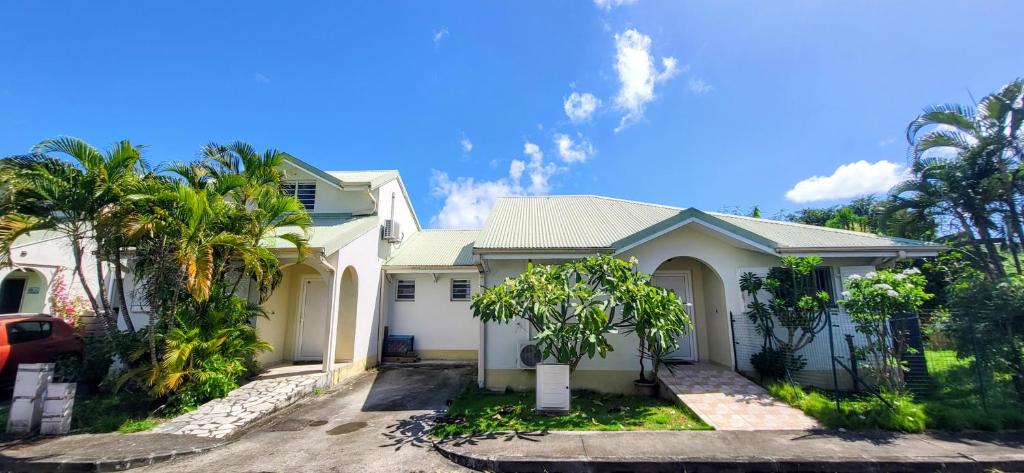 a white house with palm trees in front of it at les jardins de sainte Anne in Sainte-Anne