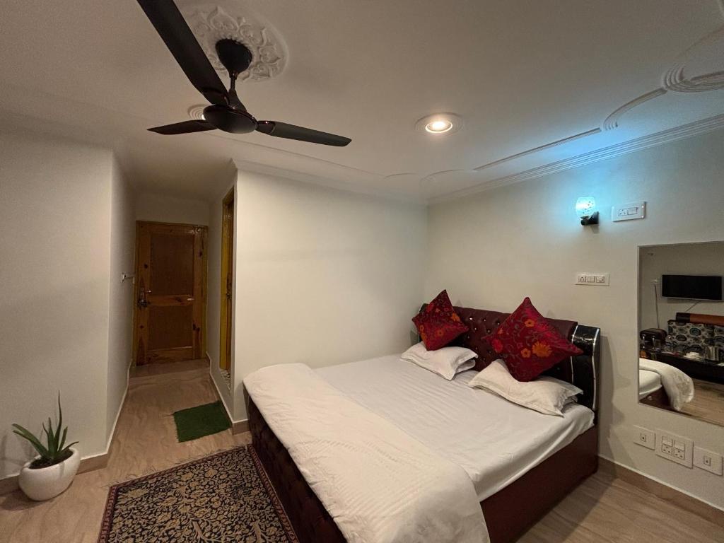 a bedroom with a bed with a ceiling fan at Hotel Crescent in Srinagar