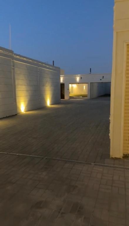 un estacionamiento vacío con un edificio en el fondo en شاليه داله العماريه2 بالكامل لك وأجواء ممتعه, en Al ‘Ammārīyah