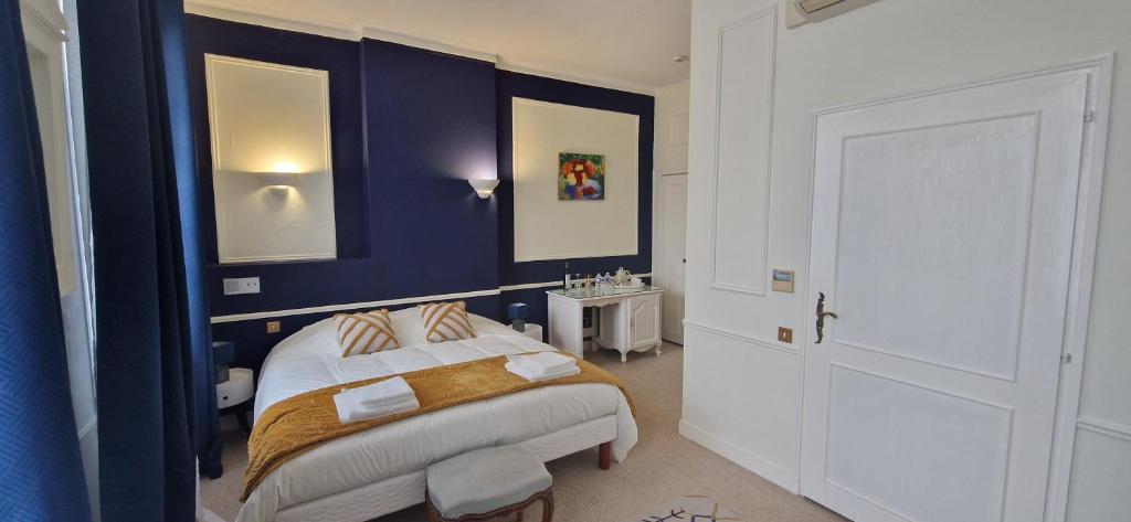 a bedroom with a bed and a blue wall at Suite Majorelle du Château in Gaillan-en-Médoc