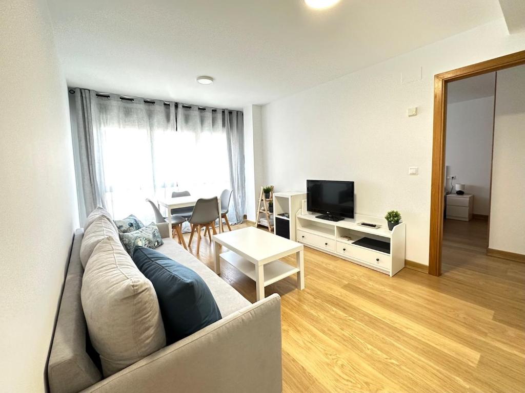 a living room with a couch and a television at Alice House in Miño