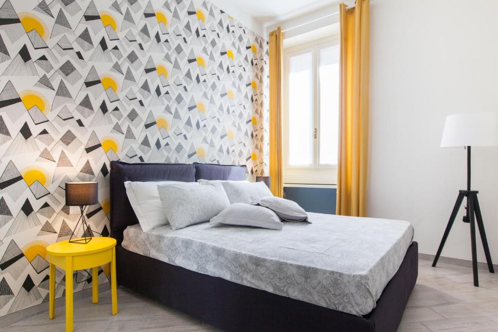 Un dormitorio con una cama y una pared con una mesa amarilla. en Milano Suite - Porta Venezia, en Milán
