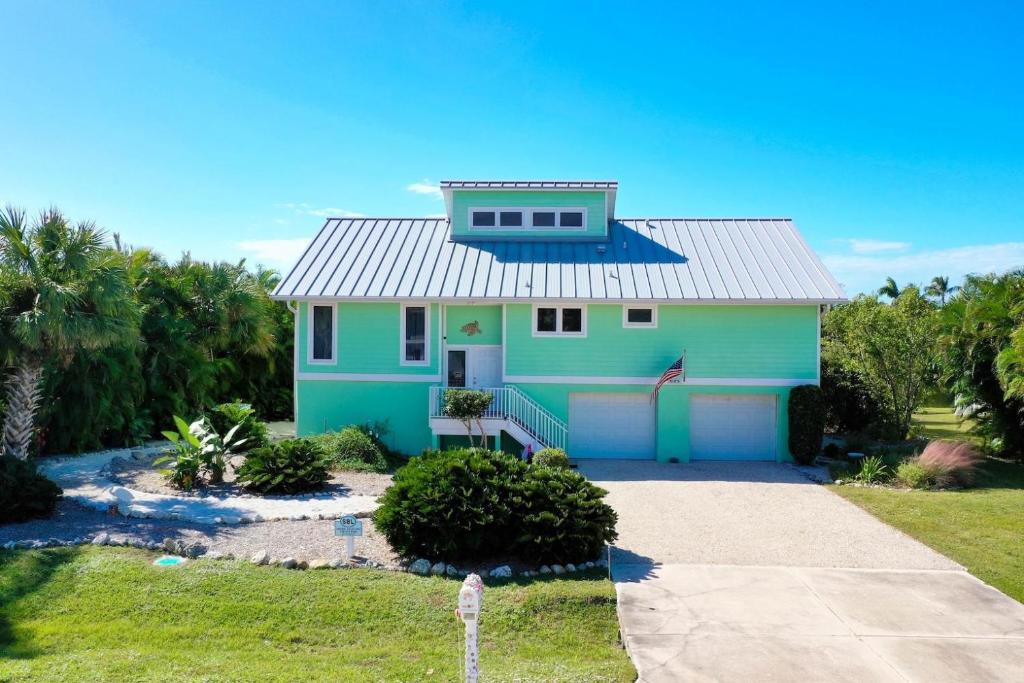 a blue and green house with a driveway at The Turtle Nest in Sanibel