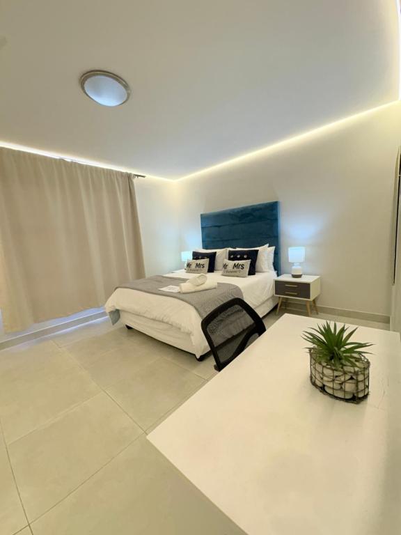 a bedroom with a bed and a plant in it at Ocean Whisper Room 6 minutes away from the beach in Cape Town