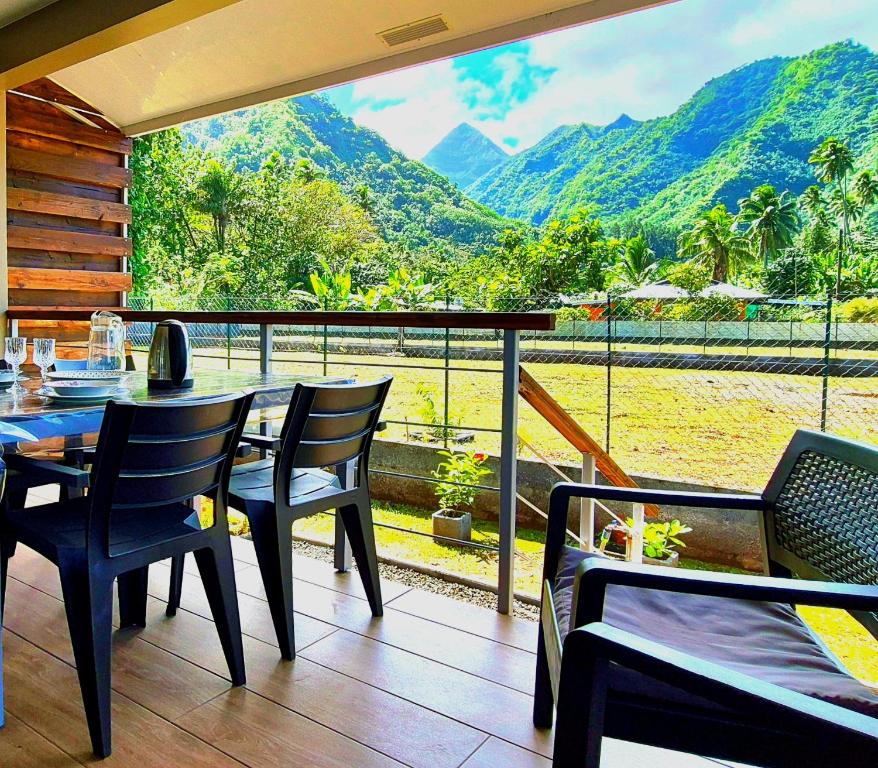 a restaurant with a table and chairs and a view of a mountain at Studio Evasion - climatisé - vue mer et montagnes - canoes et paddle offerts ! Teahupo'o Lodge Tahiti in Teahupoo