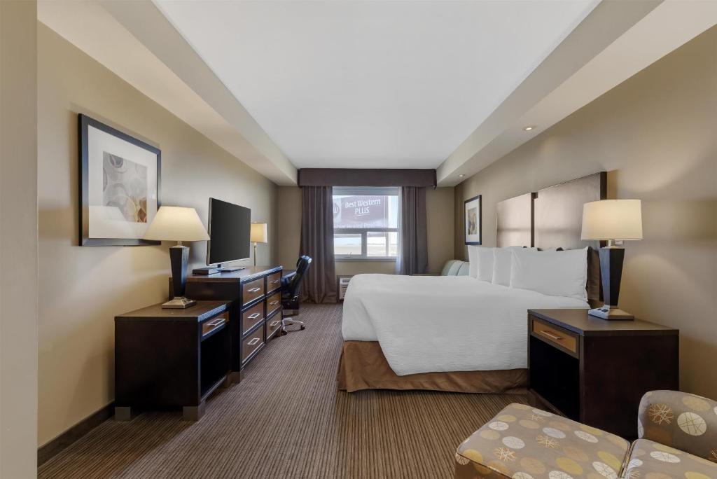 a hotel room with a large bed and a television at Best Western Plus Moose Jaw in Moose Jaw
