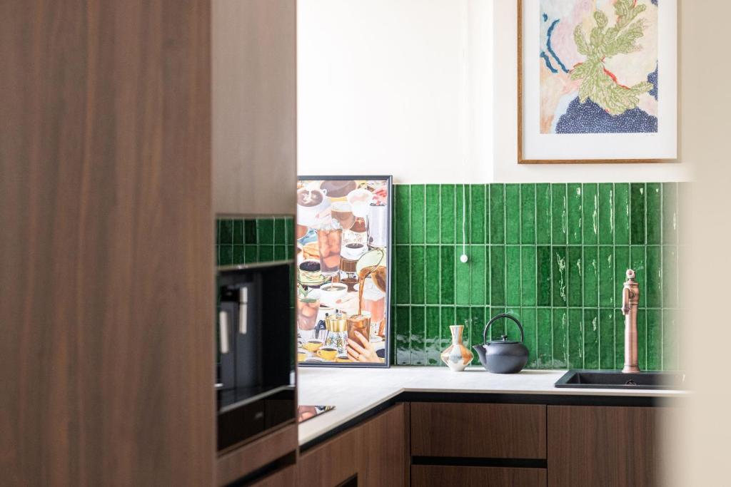 een keuken met groene tegels op de muur en een spoelbak bij 1.75 Paris La Trêve in Parijs