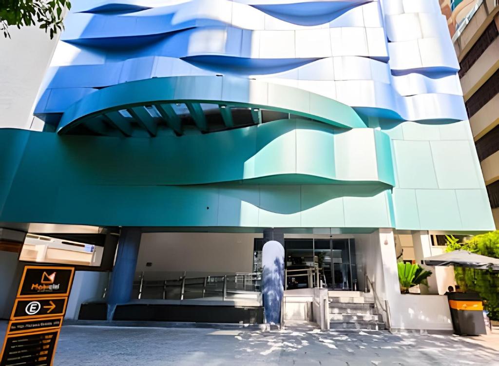 ein Gebäude mit einer blau-weißen Fassade in der Unterkunft Stay Inn com Vista Mar Parcial, Piscina, opção de estacionamento na quadra da praia in Santos