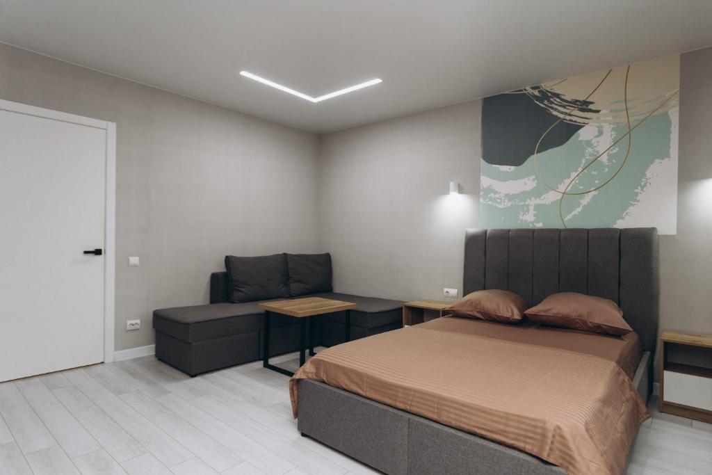 a bedroom with a bed and a couch at Luxury Apartment Lushpy Avenue - Hotel Standard in Dobrovelychkivka