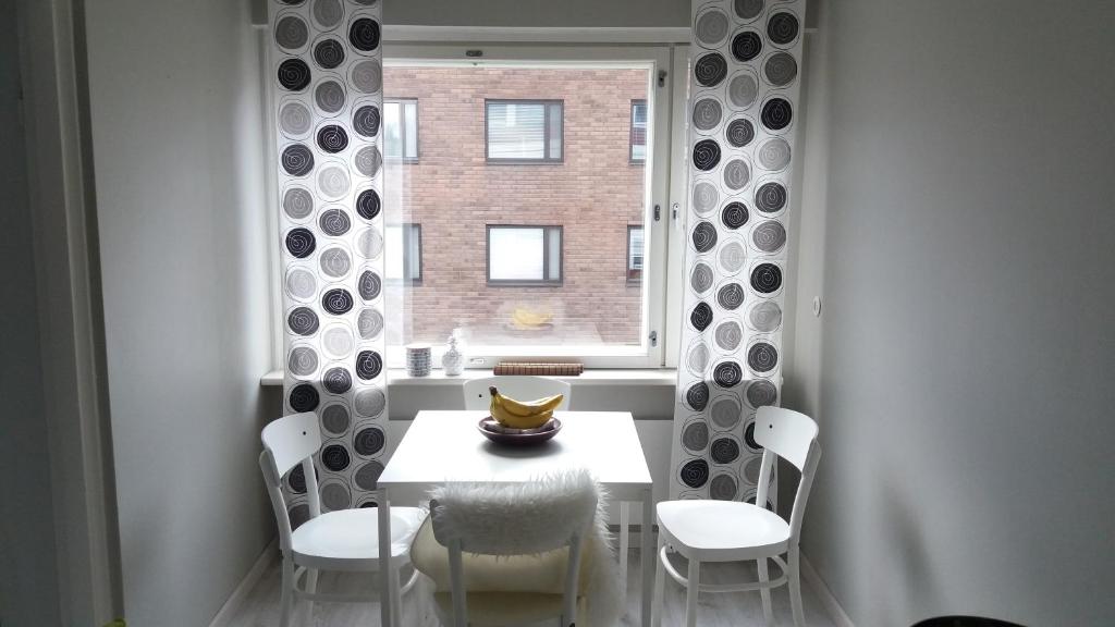 una sala da pranzo con tavolo, sedie e finestra di Apartment Vuorikatu 35 a Kuopio