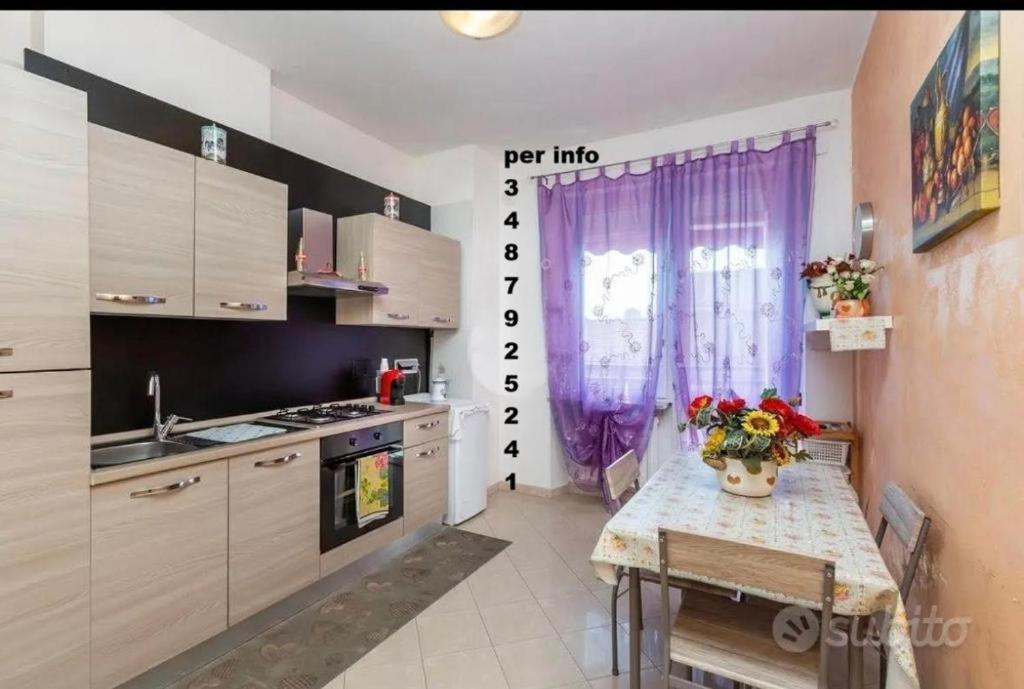 a kitchen with a table with a vase of flowers on it at Appartamento posizione comoda in Collegno
